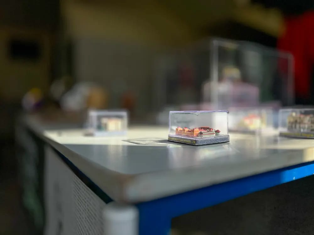 Mesa de exposição com maquetes protegidas por redomas de acrílico
