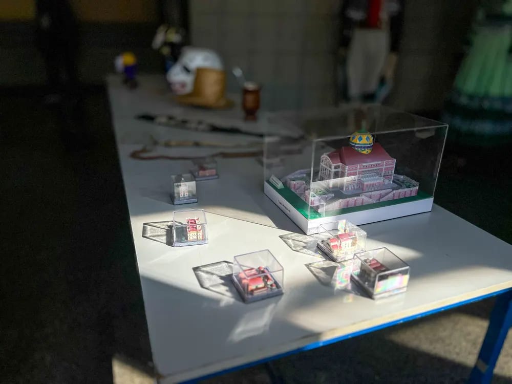 Maquetes de casario brasileiro dispostas sobre a mesa da exposição