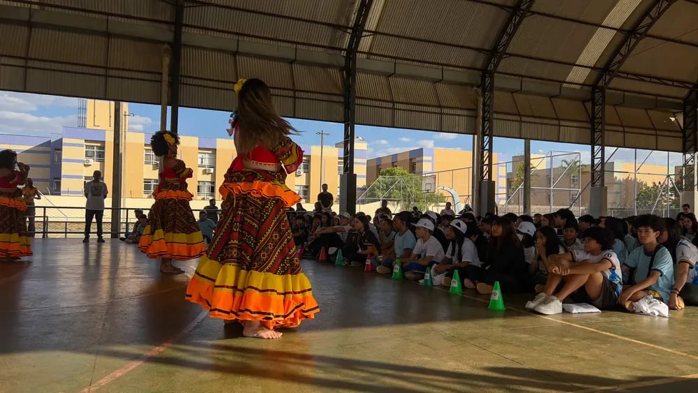 Dançarina de saia rodada se apresenta na quadra diante do público
