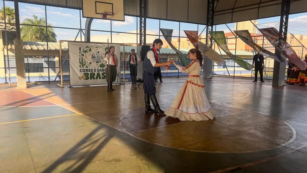 Casal de dançarinos em traje regional durante a apresentação