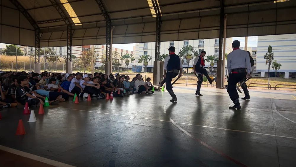 Dançarinos se apresentam na quadra diante do público sentado